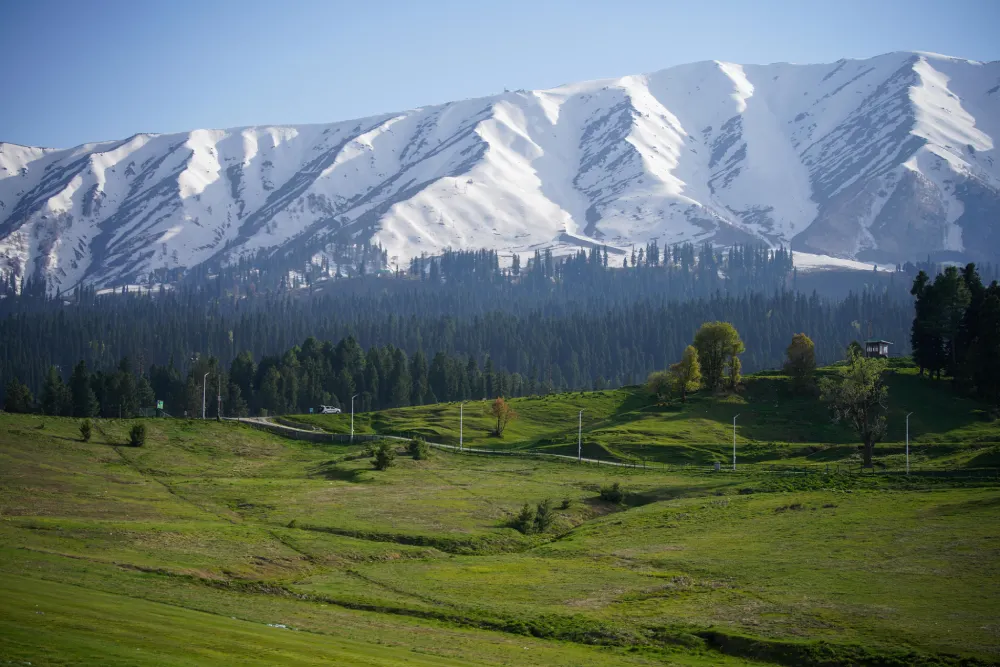 Scenic view of Kashmir valley with mountains and a calm lake for the Kashmir Bliss travel package